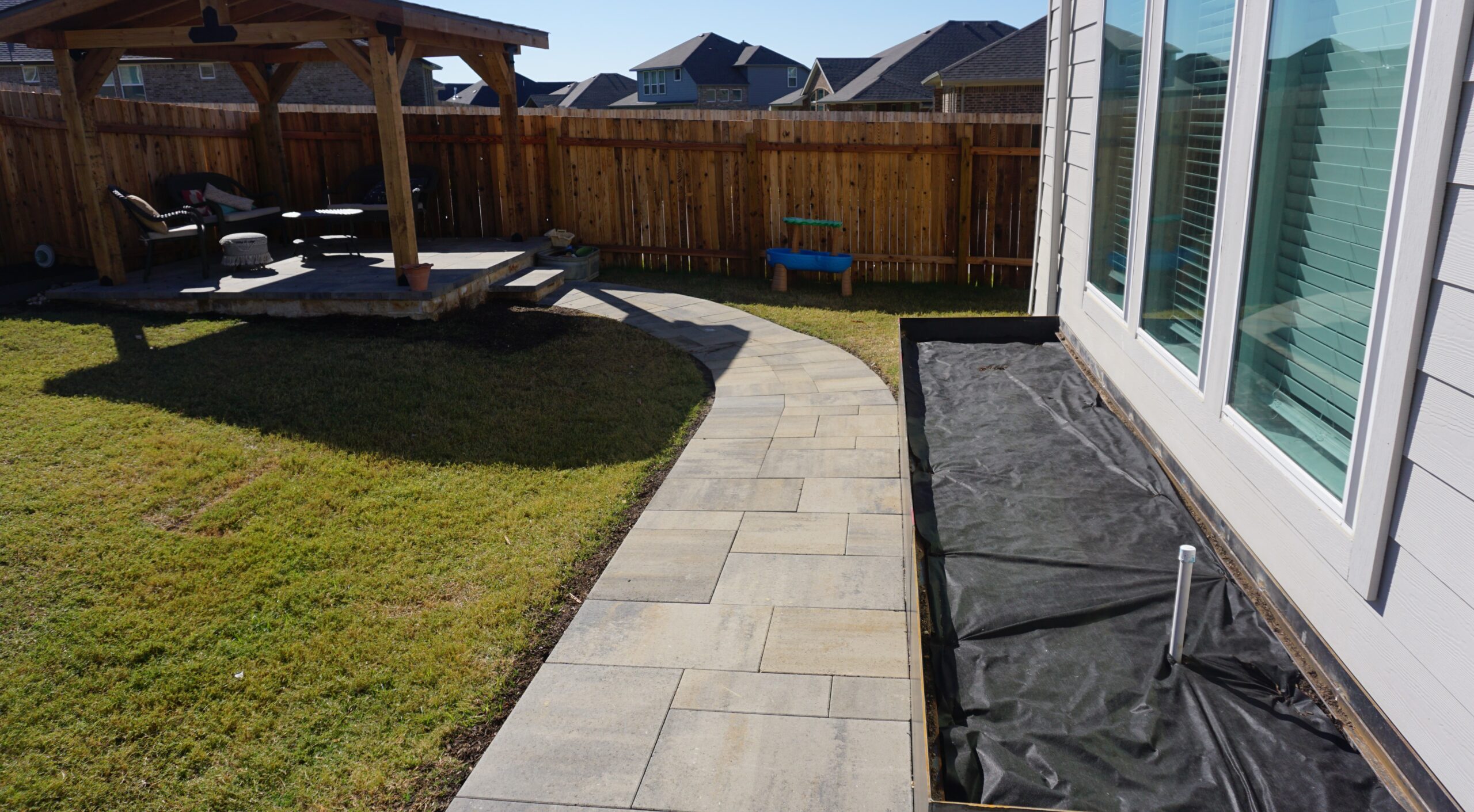 Dimensions Paver walkway leading to pergola with raised steel planter