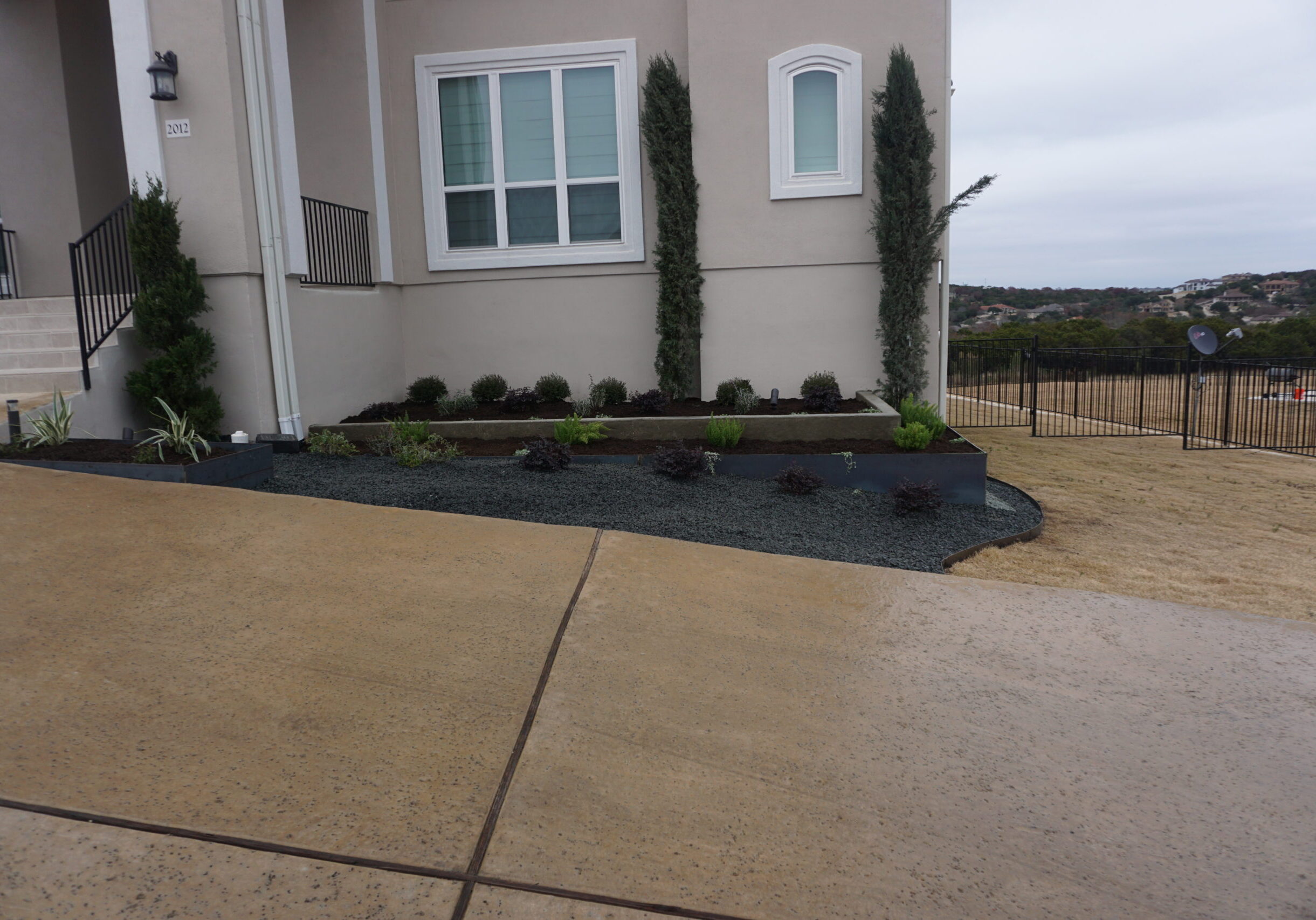 Front flowerbed 2 tier with concrete and steel beds concrete and mulched filled in with plants