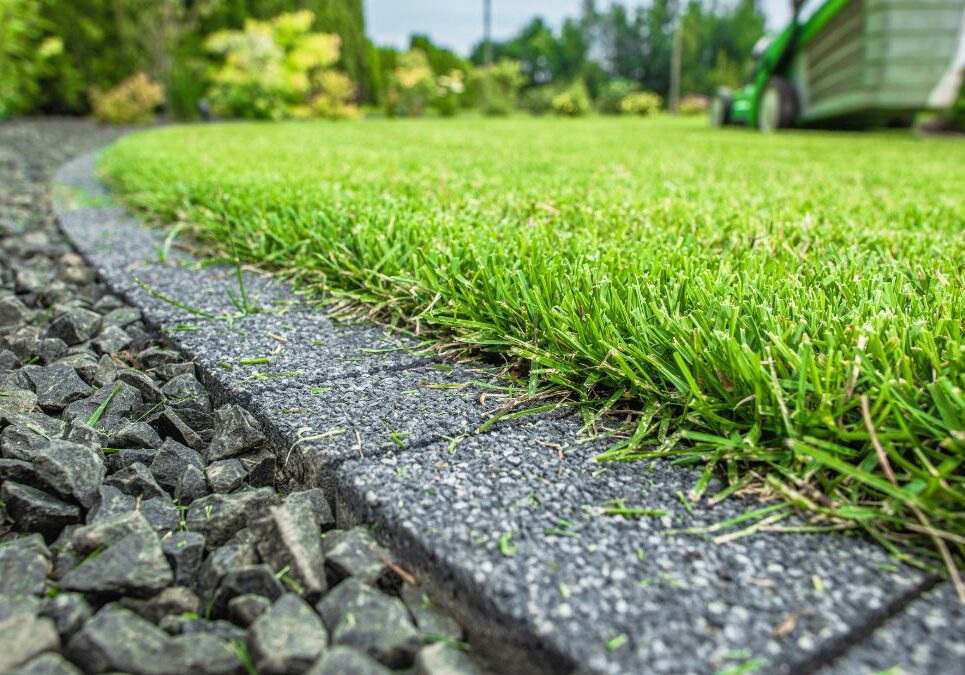 commercial lawn edging Austin, Texas Lawn with green grass in the foreground and a gravel area in the background.
