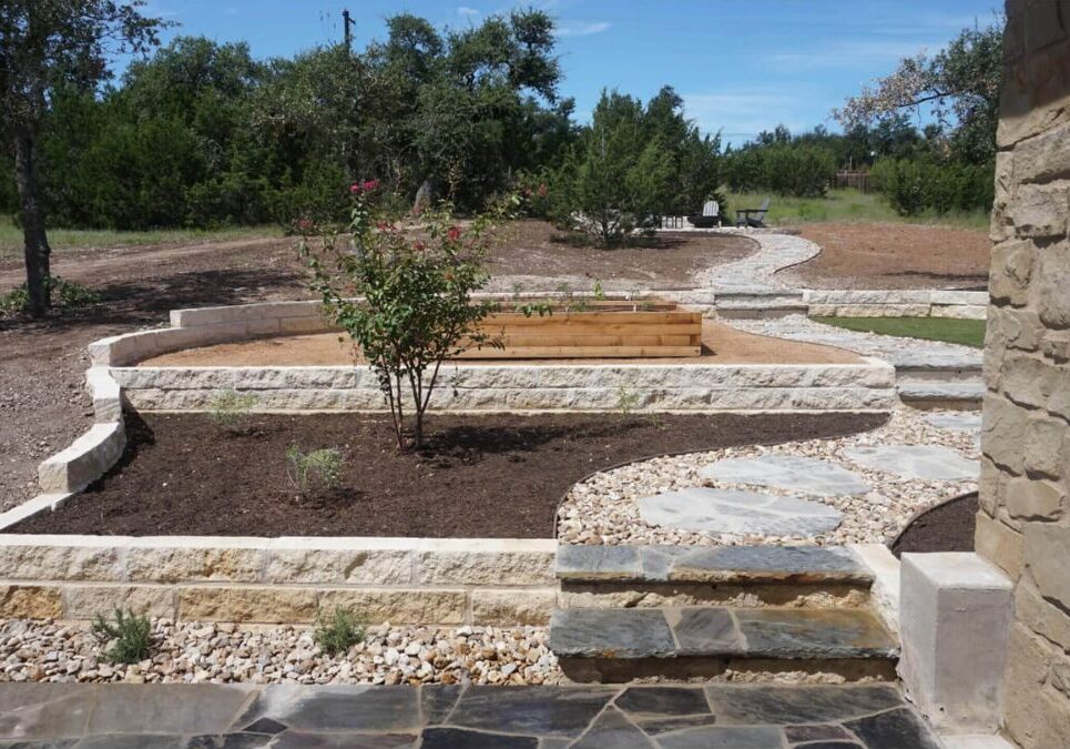 Decorative stone pathways with retaining walls and raised beds in Austin, TX landscape
