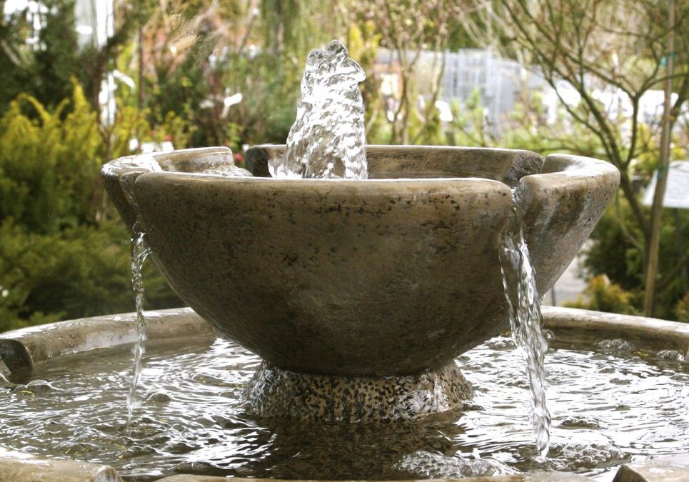 A fountain with water gracefully flowing from its spouts into a basin below.