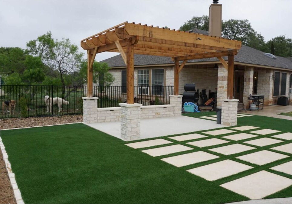 Wooden pergola with artificial turf and paver patio design in Austin, TX backyard
